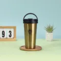 Roestvrijstalen geïsoleerde koffiebeker met handvat en houten onderzetter detail. - 500ml / Goud