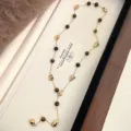 Detailed view of long necklace with natural tiger eye beads and abstract gold masks - Lava Metal Tiger's Eye Necklace (R1820)
