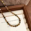 Dettaglio della collana di perle occhio di tigre naturale con accenti dorati stile Maillard - Collana Occhio di Tigre Geometrica (R5703)