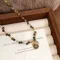 Detailed close-up of natural tiger eye beaded necklace with a golden sun pendant - Sunflower Evil Eye Tiger's Eye Necklace (R0853)