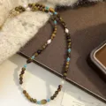Dettaglio macro di una collana di perle con occhio di tigre, perle e grani turchesi. - Collana Occhio di Tigre con Perline Naturali (R1779)