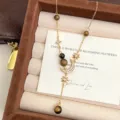 Detailed view of the vintage tiger eye necklace featuring crystal moon and star pendants - Star Moon Tassel Tiger's Eye Necklace (R0077)
