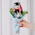 Detail von handgefertigten Häkelblumen und Plüsch-Abschlussbären-Bouquet für Studenten - Blau