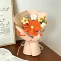 Vista dettagliata di un bouquet di cosmo fatto a mano all'uncinetto in carta regalo pesca. - Arancione