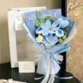 Detailed view of handmade crochet bouquet with blue flowers and heart in gift wrapping - Cosmos Tulip Rose Heart Gift Bag / Blue