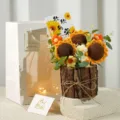 Detailed view of handmade knitted sunflower bouquet with gift bag and wooden pot for decoration. - Wooden Bucket with 3 Knitted Sunflowers - Prospering