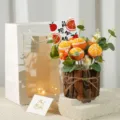 Detailed view of handmade crochet orange potted flower in rustic wooden pot with gift bag. - Wooden Bucket with 5 Oranges (Bright Future Theme)