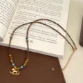 Detailed view of natural tiger eye beaded necklace with a golden rocking horse pendant - Gold Trojan Horse Tiger's Eye Necklace (R0636)
