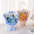 Detailed view of blue and orange soap flower bouquets with 'Love is Eternal' text. - White Window Paper Handle Bag / Blue
