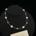 Elegant silver pearl necklace with textured beads shown on a black display stand - Station Necklace (R5247) / White