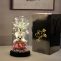 Eeuwige roos glazen koepel met schattige teddybeer en warme LED verlichting voor cadeaus. - Zwarte golfkartonnen doos, beer & gekleurde gouden bloemen