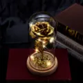 Detailed macro view of a gold foil eternal rose in a glass dome with warm LED lights - Wood Base Gold Foil Rose (Warm Light + Three Leaves) / Gold