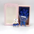 Detailed view of 7 blue soap roses bouquet with a small teddy bear in a pink gift box. - Blue