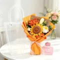 Handmade crochet sunflower and rose bouquet in orange wrapping with transparent gift bag - Orange Forget-me-not & Seeded Sunflower Bouquet / Trapezoid Bag