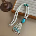 Ethnic style long beaded necklace featuring turquoise stone and shell bead tassel - Necklace