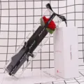 Close-up detail of a single red soap rose packaged in a clear PVC gift box with ribbon - Carnation Red