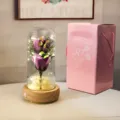 Vue détaillée de la rose éternelle violette lumineuse sous cloche avec boîte cadeau - Boîte Rose en Carton Ondulé (Base Bois + 2 Fleurs de Savon + Boîte Musique) / Violet