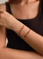 Handmade red string bracelets with red agate and silver beads shown on a model's wrist - Bracelet