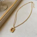 Detailansicht einer goldenen Doppelkette mit gelbem Kristallanhänger im Vintage-Stil. - Champagner Zuckerwürfel