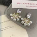 Detalle de los elegantes pendientes de perlas en forma de abanico estilo francés - Estilo Perla Semirredonda (R1217) / Dorado