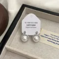 Primo piano di eleganti orecchini a perla con un alone di zirconi in una scatola di gioielli - Stile Perla Bianca Zircone (R1402)