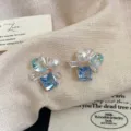 Primo piano di orecchini eleganti con zircone blu quadrato e perle bianche - Stile Perla di Zucchero Quadrata Blu (R0190)