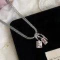 Makroansicht der silbernen dreilagigen Kette mit rosa Briefumschlag- und Zirkonia-Anhängern - Rosa Tropföl Umschlag Anhänger (R4046)
