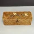 Detail view of hand-woven seagrass storage box with elegant floral embroidery decoration - Golden Rose Embroidery Style