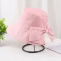 Vue détaillée d'un chapeau bob rose orné d'un grand nœud élégant sur un support noir. - Adulte 55-58cm / Rose