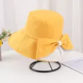 Vue détaillée d'un élégant chapeau bob jaune avec un grand nœud décoratif pour femme. - Adulte 55-58cm / Jaune Bicolore