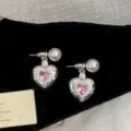 Vista dettagliata di squisiti orecchini a cuore in zircone rosa con perle su velluto nero - Orecchini Cuore Rosa (R2646) / Argento