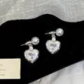 Detailed view of silver heart stud earrings with sparkling zircons and white pearls - White Heart Stud Earrings (R2838)