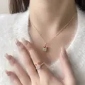 Primo piano del set collana e anello con renna di Natale su una modella con maglia - Collana Cervo Rosso / Rosso
