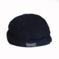 Detailed macro view of a navy blue corduroy docker cap with a vintage brand label - Adult 55-58cm / Navy Blue