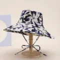 Detail view of the blue and white floral print wide brim bucket hat closeup fabric texture. - Flower Creamy White