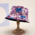 Detailed view of floral print bucket hat on wooden display stand for sun protection - Pink Purple Blue
