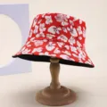Detailed view of red floral bucket hat with cherry blossom print on a wooden stand - 红白樱花印花