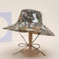 Details of the wide-brim tropical leaf bucket hat featuring digital print and chin ties. - Leaf White