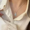 Elegante collana con ciondolo a stella in argento e zirconi blu indossata da una modella. - Collana Blu Pentagramma Zirconia (R5470)