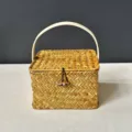 Detailed front view of a square woven straw gift box with a toggle lid and handle - Small (14*14*9cm) / Natural Straw Color