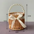 Detailed macro view of handmade wicker wedding basket with pearl handle and satin bow - White Elegant Round Basket