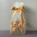 Detail shot of a golden wire gift basket wrapped in sheer white tulle with elegant gold satin ribbons. - Square Basket / Gold Snow Yarn