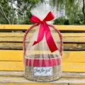 Detailed macro view of a round hand-woven straw gift basket with a red ribbon - Basket With Cream Mesh And Ribbon / Noble Red