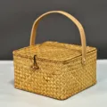Gros plan détaillé d'une boîte cadeau carrée en rotin tressé avec sa poignée en cuir - Grand (20*20*11cm) / Couleur Paille Naturelle