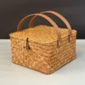 Vue détaillée d'un panier-cadeau tissé carré avec poignées en cuir marron et fermeture bouton - Panier à Double Poignée / Grand (20*20*11cm) / Couleur d'origine