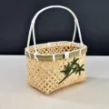 Vue détaillée d'un panier en bambou artisanal avec applique de feuilles et anse solide - Panier rectangulaire charme bambou