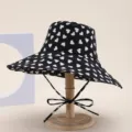Stylish black bucket hat with white heart pattern, large brim for sun protection. - Black Heart