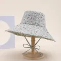 Detailed view of the floral bucket hat with adjustable ties and wide brim, light blue fabric. - Flower Green