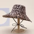 Stylish leopard print bucket hat with wide brim and cute bow tie chin strap for women. - Leopard Coffee