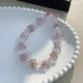 Handmade pink floral beaded phone charm with iridescent accents for a sweet aesthetic look - Pink